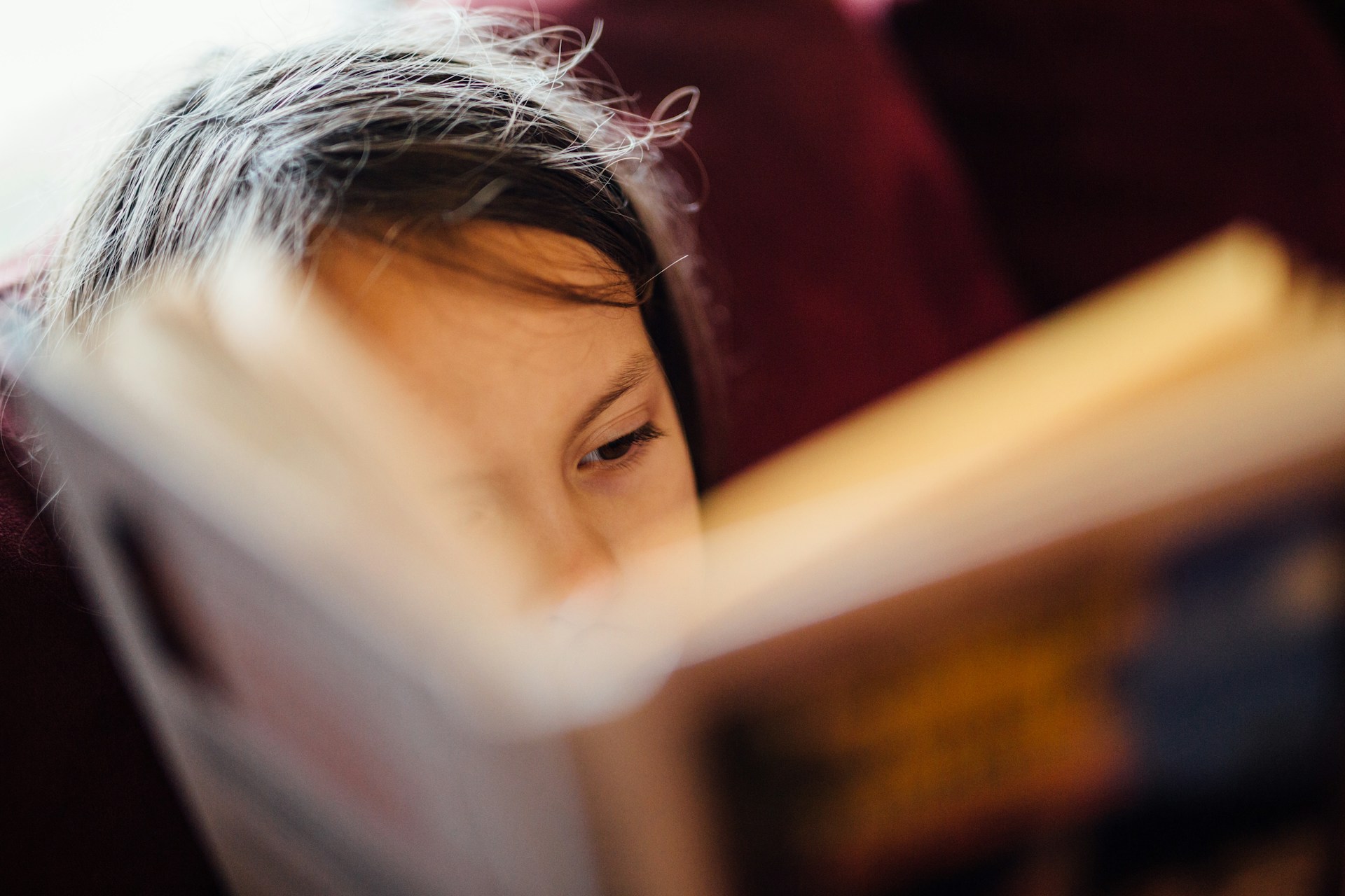 (c) unsplash Kind blickt in Buch