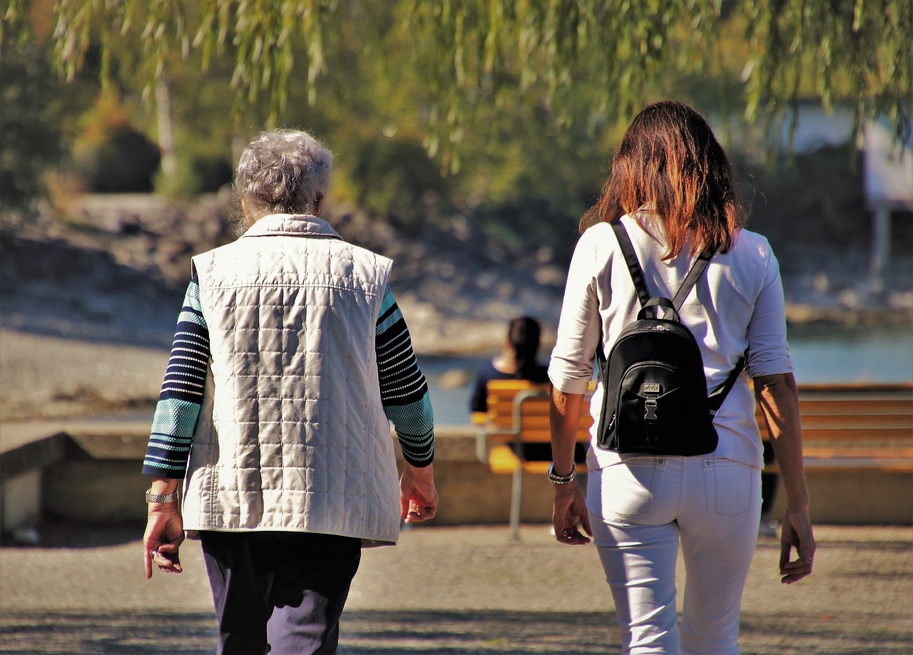 Jüngere und ältere Frau beim Spaziergang im Park