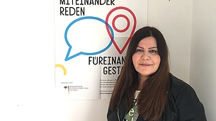 Farzaneh Motefaregheh neben einem MGH-Poster