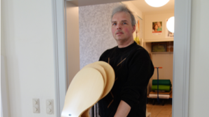 Thomas Hohl trägt einen Stapel Stühle